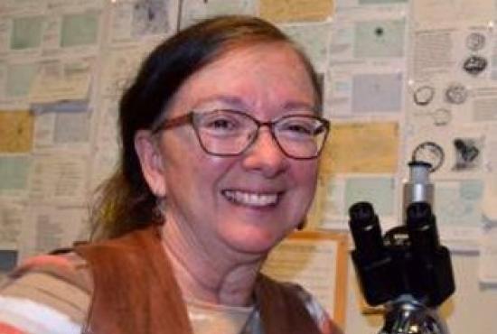 An image of Deborah Pearsall, smiling and posing in her lab.